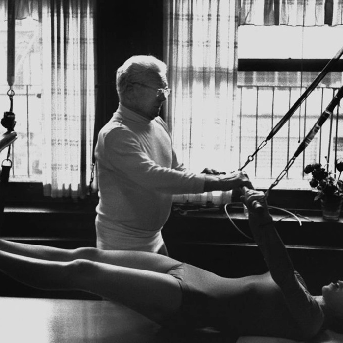 Joseph Pilates, inventeur de la méthode Pilates Joseph Pilates donnant un cours a une jeune femme