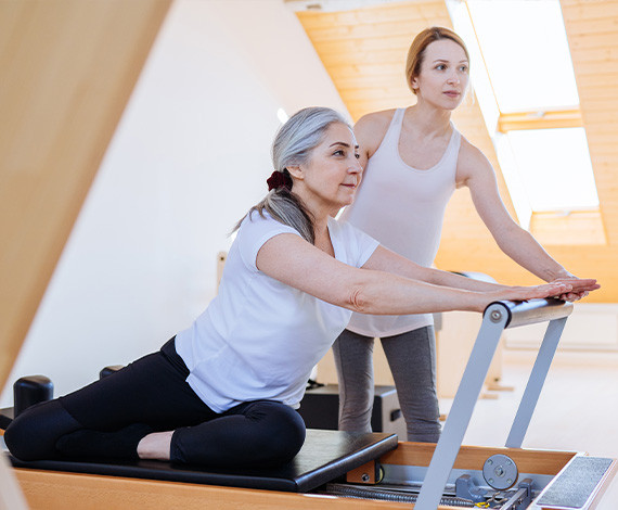 Photo d'une professeur de Pilates avec son élève